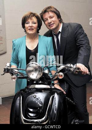 Gli chef Jamie Oliver e Delia Smith si siedono su uno scooter per essere portati alla Jamie Oliver Foundation durante la Big Night out di Jamie Oliver alla cripta della cattedrale di St Paul, Londra. Foto Stock