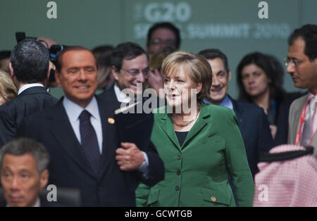 La cancelliera tedesca Angela Merkel (al centro) con il primo ministro italiano Silvio Berlusconi (a sinistra) al vertice del G20 a Seul, Corea del Sud. PREMERE ASSOCIAZIONE foto. Data immagine: Venerdì 12 novembre 2010. I leader mondiali al vertice del G20 di Seoul oggi si lotteranno per inventare un linguaggio su cui tutti possono concordare per una comunità finale che pochi si aspettano di risolvere le questioni chiave della valutazione monetaria e del commercio. Il primo ministro David Cameron ha lanciato un monito ai colleghi leader ieri sera per non ripetere gli errori degli anni trenta, quando le barriere protezionistiche erette per difendere le economie nazionali hanno portato a un Foto Stock