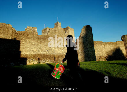 Un pedone passa lo storico Trim Castle, il più grande castello anglo-normanno in Irlanda a Trim, Co. Meath oggi. Foto Stock