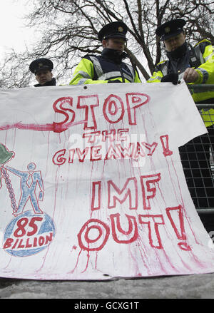 Gardai rimuove le bandiere di protesta mentre le persone si riuniscono prima del budget di oggi alla Leinster House di Dublino. Foto Stock