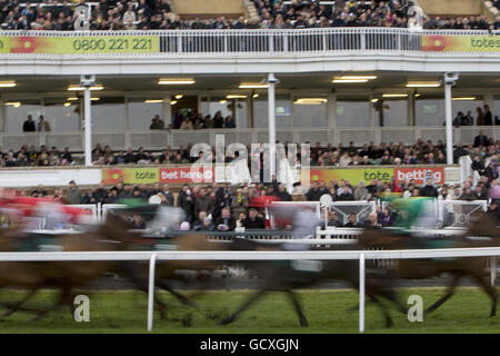 Corse di cavalli - Becher Chase Day - Ippodromo di Aintree. I corridori e i corridori corrono oltre gli stands in una sfocatura come sguardo dello spettatore sopra Foto Stock