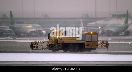 Un camion spruzza lo sbrinatore sulla pista dell'aeroporto di Dublino. Foto Stock