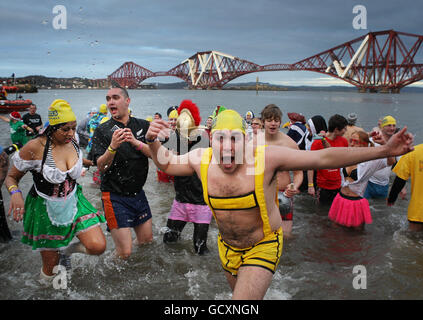 I nuotatori sfidano il freddo nel fiume Forth vicino Edimburgo, durante il Loony Dook, uno dei nuotatori annuali di Capodanno che si svolgono in tutto il Regno Unito. Foto Stock