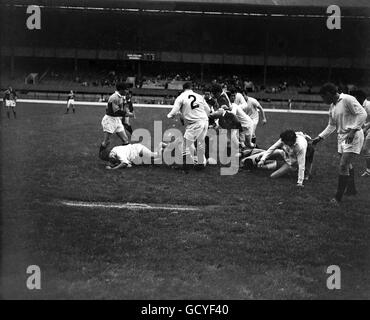 I giocatori di entrambe le squadre vanno per possesso come la palla si trova nella parte allentata Foto Stock