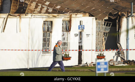 Un inmate cammina vicino al centro di induzione bruciato in HM Prison Ford vicino alla palestra bruciata in HM Prison Ford vicino Arundel, West Sussex dopo un rampage da circa 40 detenuti. Foto Stock