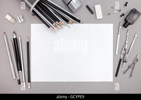 Area di lavoro di designer con carta bianca, matite e vari strumenti di disegno, vista dall'alto Foto Stock