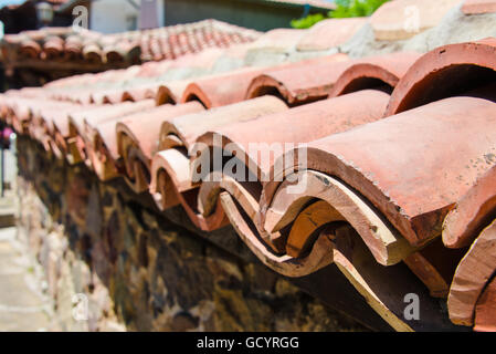 Close up di recinzione in pietra coperta con tetto di tegole di argilla in Sozopol Bulgaria Foto Stock