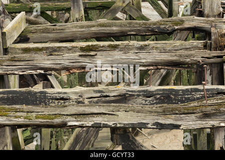 Righe di chiudere i dettagli di weathered supporti strutturali al molo vecchio dove decking è marcio e si sono allontanati lasciando rovere principale Foto Stock