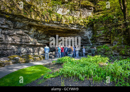 Persone su tour guidato di Jack Daniel's distilleria motivi' sito di ubicazione della grotta di acqua sorgiva di Lynchburg, TN Foto Stock