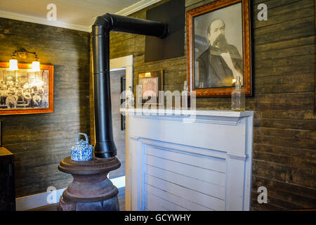 Una foto di Jack Daniel's sovrasta la mantel & pentola stufa panciuto nella parte interna della distilleria Office di Lynchburg, TN Foto Stock