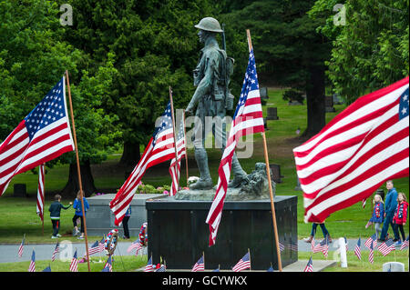 Giorno Memoriale della cerimonia al cimitero con bandierine americane scultura militare a siti di grave Foto Stock