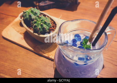 Frullato di mirtilli con menta in mason jar mug con paglia e cactus. Al di sopra di vista sul legno. Foto Stock