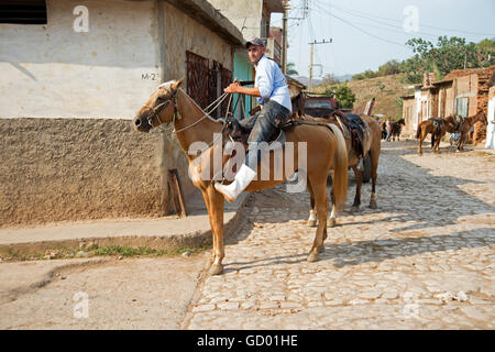 Un cubano guarjiro o cowboy tenendo i suoi cavalli casa dopo assunzione di turisti in gita a cavallo della campagna in Trinidad, Cuba Foto Stock