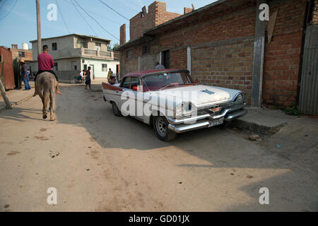 Un vintage anni cinquanta la vettura americana utilizzato come un taxi parcheggiato in una strada a ciottoli in Trinidad Cuba come un uomo cubano passato passeggiate a cavallo Foto Stock