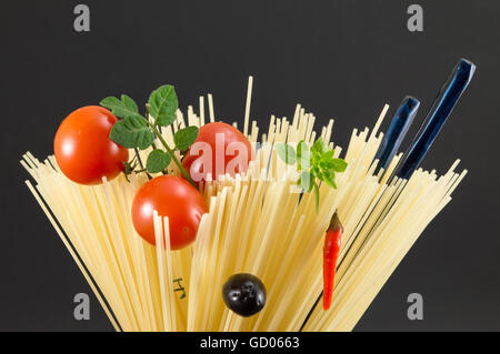 Materie spaghetti con pomodoro e olive poste in forma a spirale pronti per la cottura Foto Stock