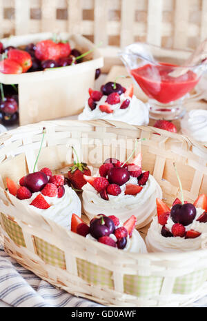 Mini Pavlova meringa torta decorata con un fresco e fragola e ciliegia Foto Stock