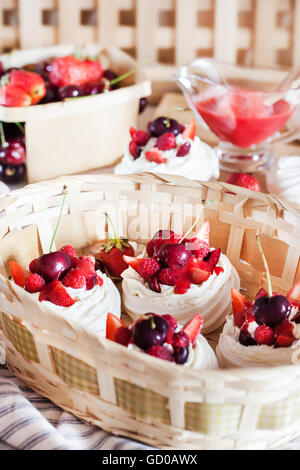 Mini Pavlova meringa torta decorata con un fresco e fragola e ciliegia Foto Stock