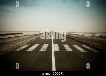 Vuoto strada scuro vicino il CHOTT EL JERID, Tunisia Foto Stock