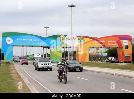 (160710) -- RIO DE JANEIRO, luglio 10, 2016 (Xinhua) -- Un motociclista in posa per una foto come cavalca attraverso il portico decorato con Rio 2016 Giochi mascotte e slogan sul modo di Tom Jobim Aeroporto Internazionale di Rio de Janeiro in Brasile il 7 luglio 2016. Il 2016 Rio i Giochi olimpici si terranno dal 5 agosto al 21. (Xinhua/Li Ming) Foto Stock