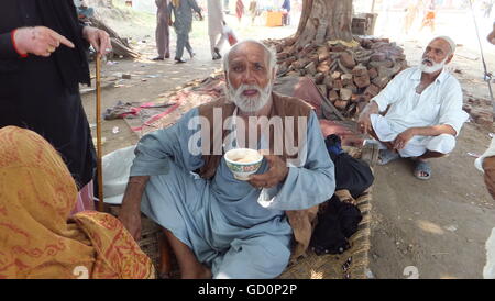 Un vecchio uomo sta godendo di tè in occasione della 456th anniversario Urse () del famoso Santo Hazrat Shah Behlole Diryai in Pindi Bhattian città del Punjab Pakistan. Foto Stock