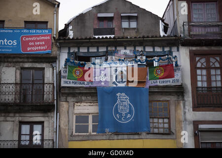 Porto, Portogallo. 10 Luglio, 2016. Un edificio con le bandiere dei giochi precedenti. I fan hanno guardato il gioco teletrasmesso su varie schermo gigante a PraÂa da Liberdade. Il Portogallo è un fan celebrare la nazionale di calcio la vittoria dell'Euro 2016 finale di partita di calcio contro la Francia, a Porto, Portogallo. Credito: Manuel Balles/ZUMA filo/Alamy Live News Foto Stock