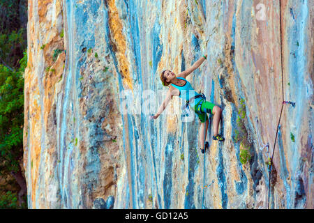 Giovane scalatore femmina verticale ascendente parete rocciosa Foto Stock