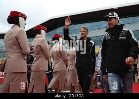 McLaren Jenson Button onde per la folla durante la parata dei piloti prima del 2016 British Grand Prix sul circuito di Silverstone, Towcester. Foto Stock