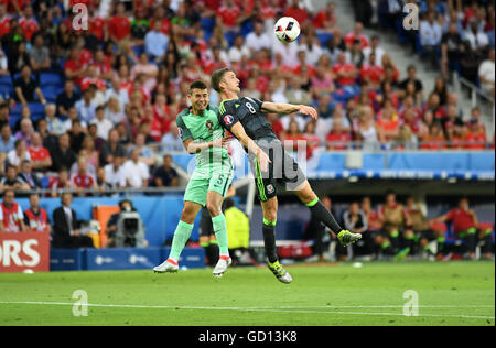 Andy King del Galles batte Raphael Guerreiro del Portogallo nella prima metà durante l'Euro 2016 Semi-Final tra il Portogallo e il Galles al Parc Olympique Lione Lione in Francia questa sera. Foto Stock