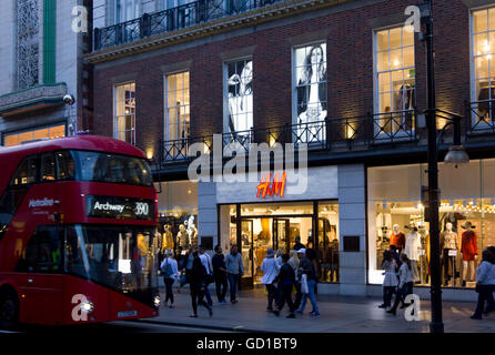 LONDON, Regno Unito - 11 settembre 2015: H&M negozio in Oxford Street a Londra, con gente che cammina e il tradizionale bus rosso Foto Stock