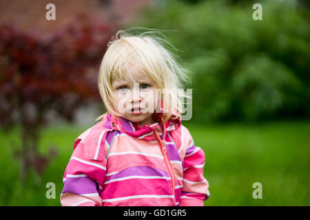 Triste o disorientati ragazza in piedi da solo in giardino Foto Stock