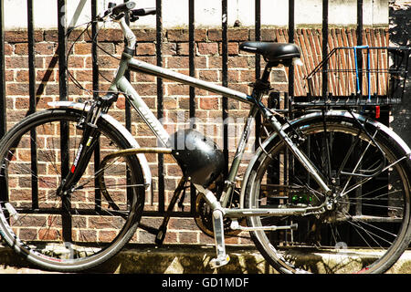 Immagine di una bicicletta fissata ad un ferro da stiro o ringhiera in acciaio recinzione in Londra Foto Stock