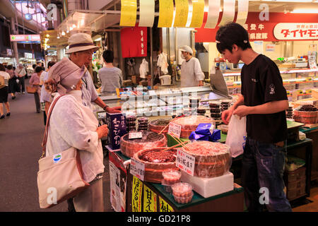 Agli acquirenti di effettuare l'acquisto presso Omicho cibi freschi di mercato, occupato e coperte colorate vie fiancheggiate da stalle, Kanazawa, Giappone, Asia Foto Stock