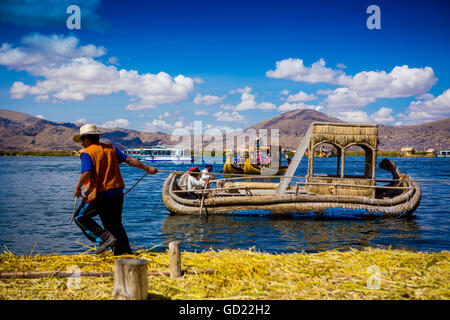 Il quechua famiglia indiana su erba flottante isole di Uros, il lago Titicaca, Perù, Sud America Foto Stock