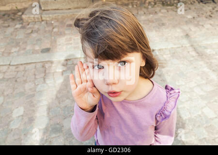 Divertente carino bionda caucasica Baby girl in rosa camicetta parla tranquillamente Foto Stock