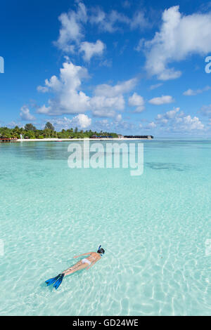 La donna lo snorkeling a Olhuveli Beach and Spa Resort South Male Atoll, Kaafu Atoll, Maldive, Oceano Indiano, Asia Foto Stock