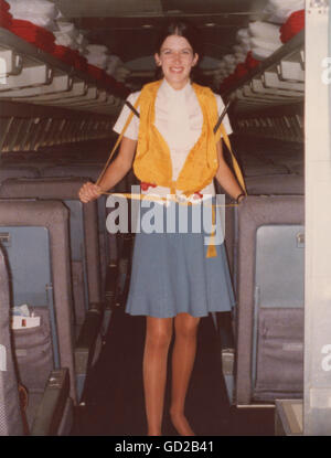 Pan American Airlines Flight Stewardess che dà a bordo 707 Annuncio di sicurezza indossare giubbotto di vita giallo, 1973, Stati Uniti Foto Stock