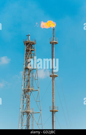 Il petrolio e il Gas Flare oltre il cielo blu a luce del giorno Foto Stock