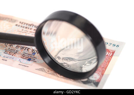 La valuta indiana rupia nota con lente di ingrandimento isolati su sfondo bianco Foto Stock