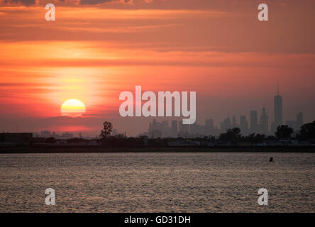 Manhattan come visto dalla Giamaica Bay, un rifugio della fauna selvatica che giace tra Brooklyn e Queens, al tramonto nei primi giorni di luglio. Foto Stock