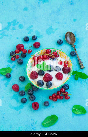 Un sano yogurt con lamponi, mirtilli e ribes rosso Foto Stock