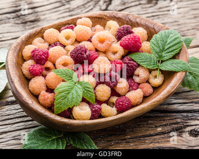 Lamponi nella ciotola di legno sul tavolo. Foto Stock