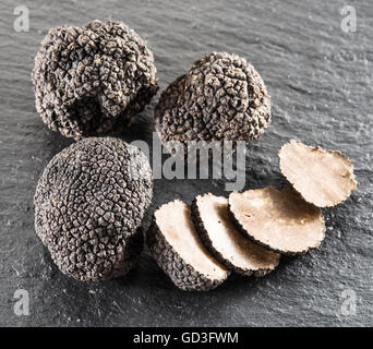 Tartufo nero e fettine di tartufo sulla scheda di grafite. Foto Stock