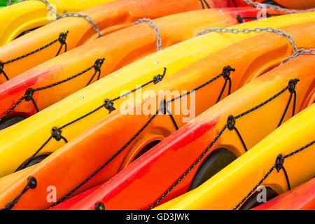 Kayaks colorati che giacciono sul loro lato in corrispondenza di un noleggio di kayak posto al Lago Sammamish State Park, Issaquah, Washington, Stati Uniti d'America Foto Stock