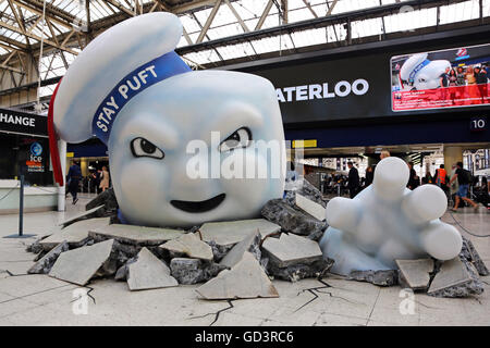 Il gigante di Marshmallow Man di Ghostbusters è visto la rottura attraverso il pavimento della stazione Waterloo di Londra come la pubblicità Foto Stock