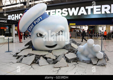 Il gigante di Marshmallow Man di Ghostbusters è visto la rottura attraverso il pavimento della stazione Waterloo di Londra come la pubblicità Foto Stock