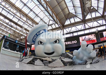 Il gigante di Marshmallow Man di Ghostbusters è visto la rottura attraverso il pavimento della stazione Waterloo di Londra come la pubblicità Foto Stock