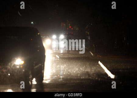 San Juan, Puerto Rico. Il 25 giugno, 2013. Protetto da un ombrello, un senzatetto donna cammina sotto la pioggia in corrispondenza di una intersezione a San Juan, Puerto Rico, Giugno 25, 2013. © Ricardo Arduengo/via filo di ZUMA ZUMA/filo/Alamy Live News Foto Stock