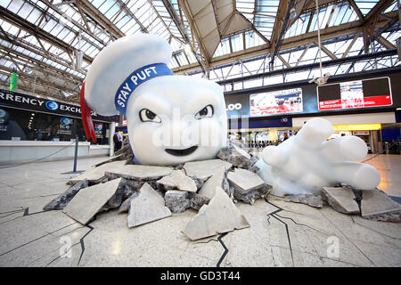 Il gigante di Marshmallow Man di Ghostbusters è visto la rottura attraverso il pavimento della stazione Waterloo di Londra come la pubblicità Foto Stock