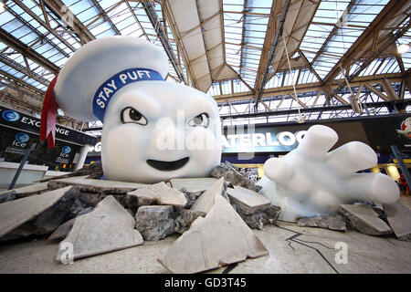 Il gigante di Marshmallow Man di Ghostbusters è visto la rottura attraverso il pavimento della stazione Waterloo di Londra come la pubblicità Foto Stock