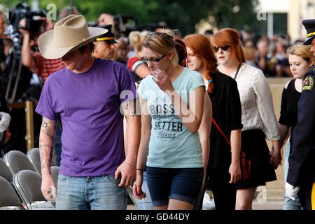 Dallas, Texas, Stati Uniti d'America. 12 Luglio, 2016. Gli amici e la famiglia degli uccisi ufficiali vengono accompagnati in una veglia presso il municipio il lunedì 11 luglio, 2016 a Dallas. Cinque poliziotti sono stati uccisi il 7 luglio quando un cecchino ha aperto il fuoco durante una manifestazione di protesta nel centro di Dallas. Credito: Kevin Bartram/Alamy Live News Foto Stock